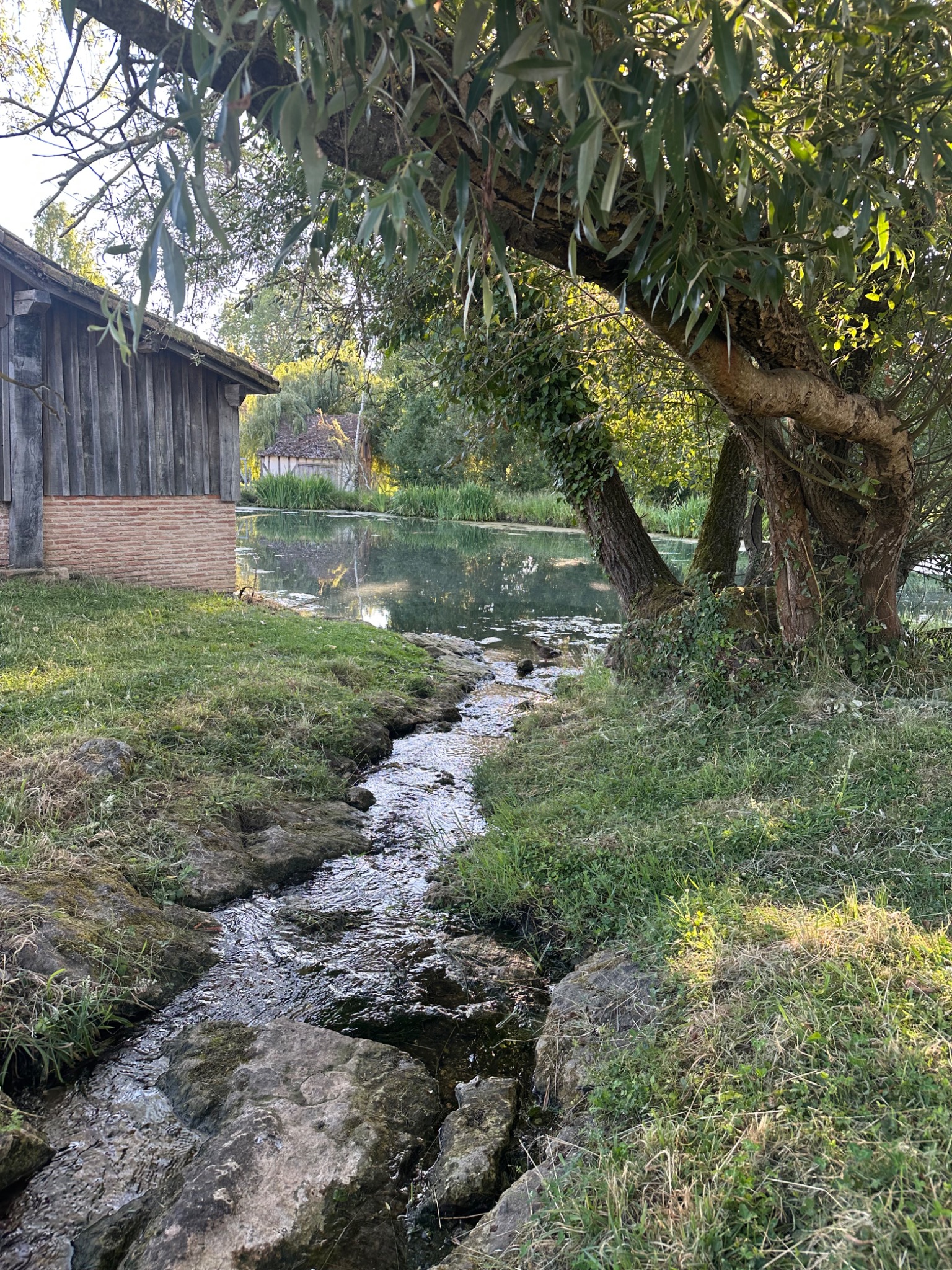 Water, trees, and a dwelling in the French countryside